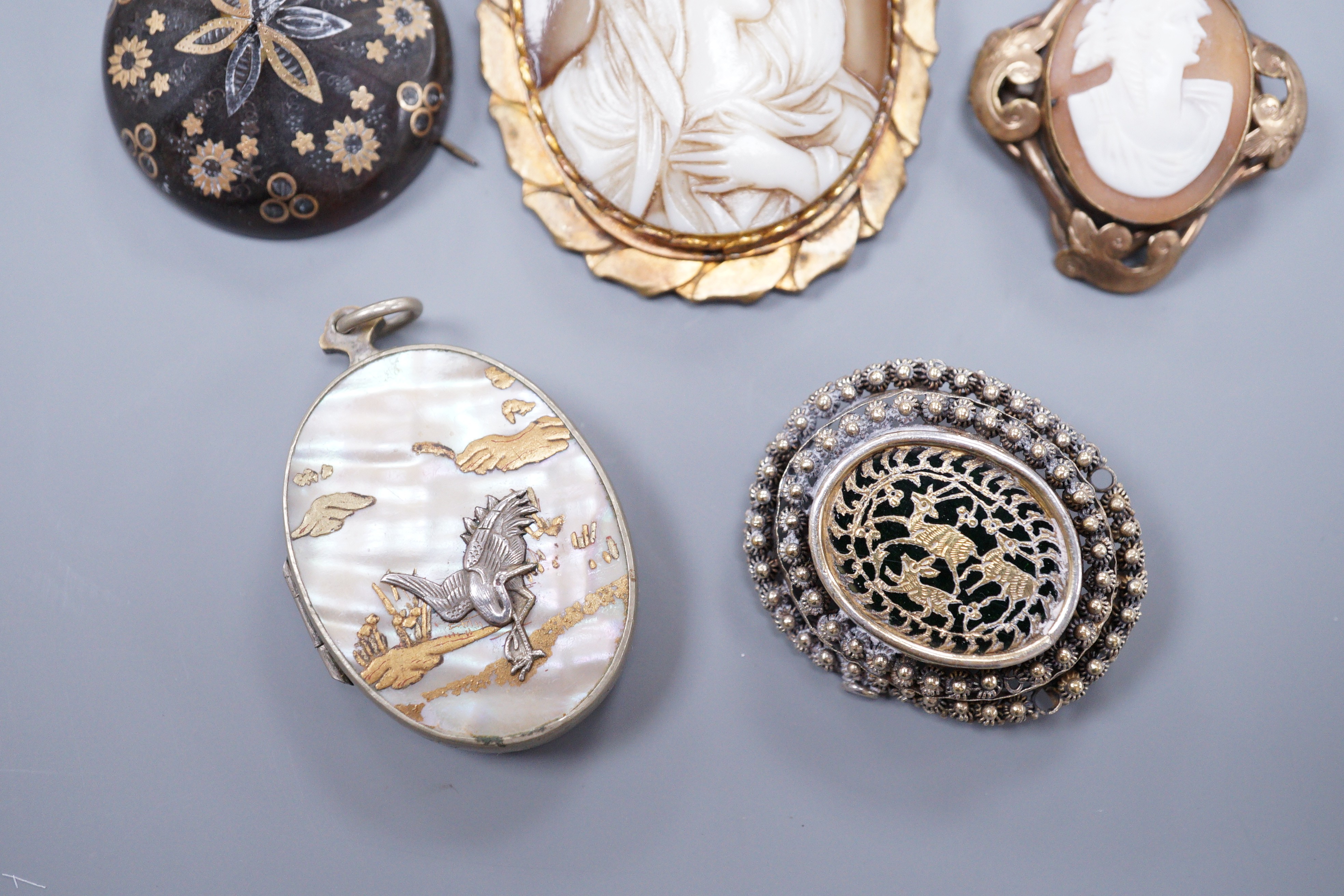 A Victorian gold pique circular brooch, 3cm (a.f.), two cameo brooches, a gilt metal brooch and a Japanese mother of pearl locket